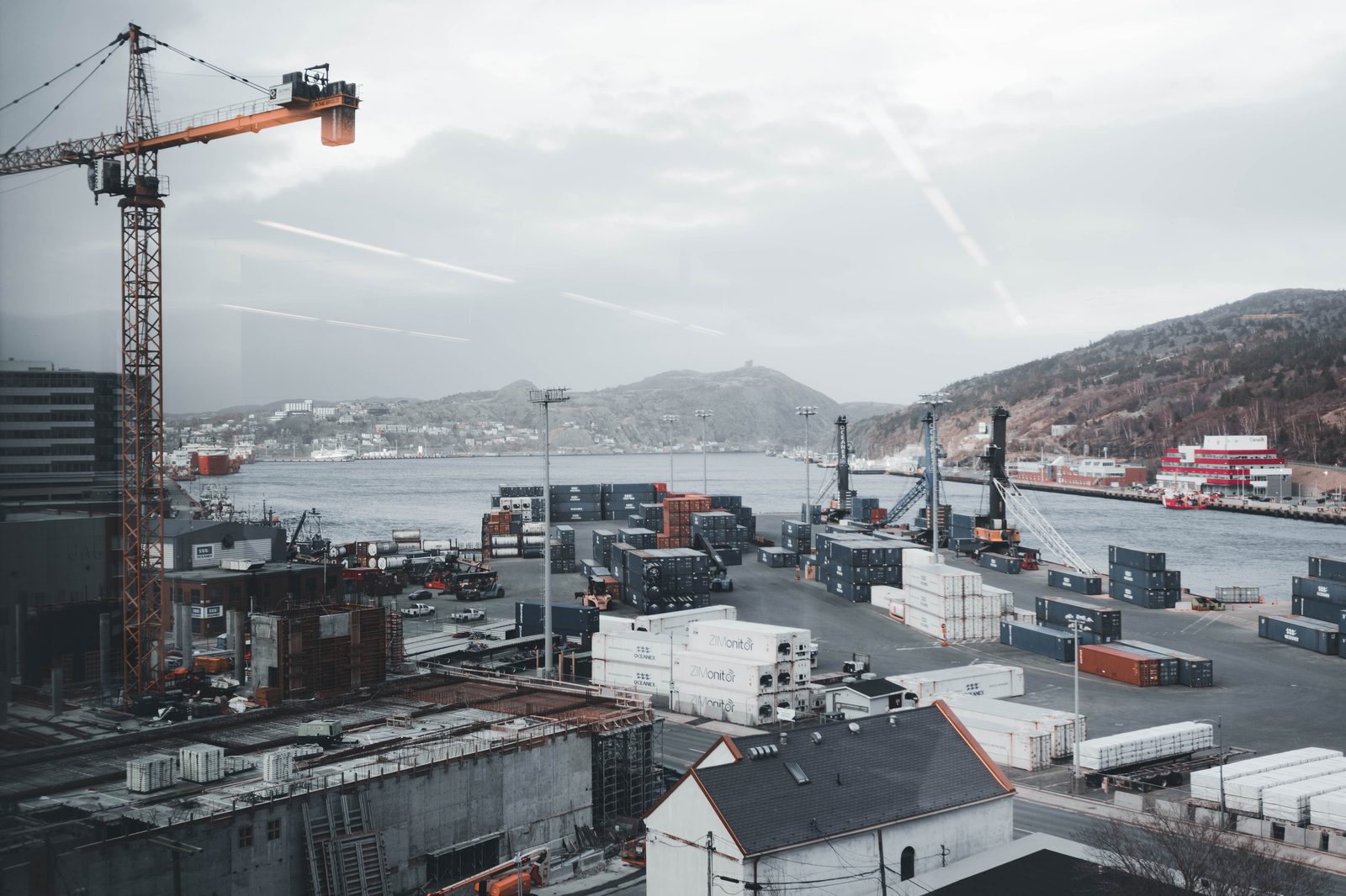 Port harbor with containers, cranes, and mountains